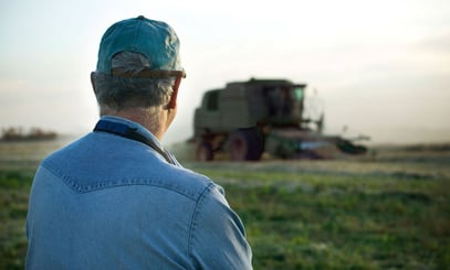 Mand der kigger på en mark og traktor