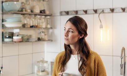 Dame i køkken med kaffe