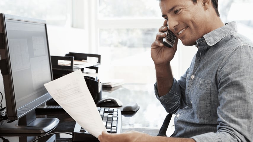 Mand på kontor taler i telefon